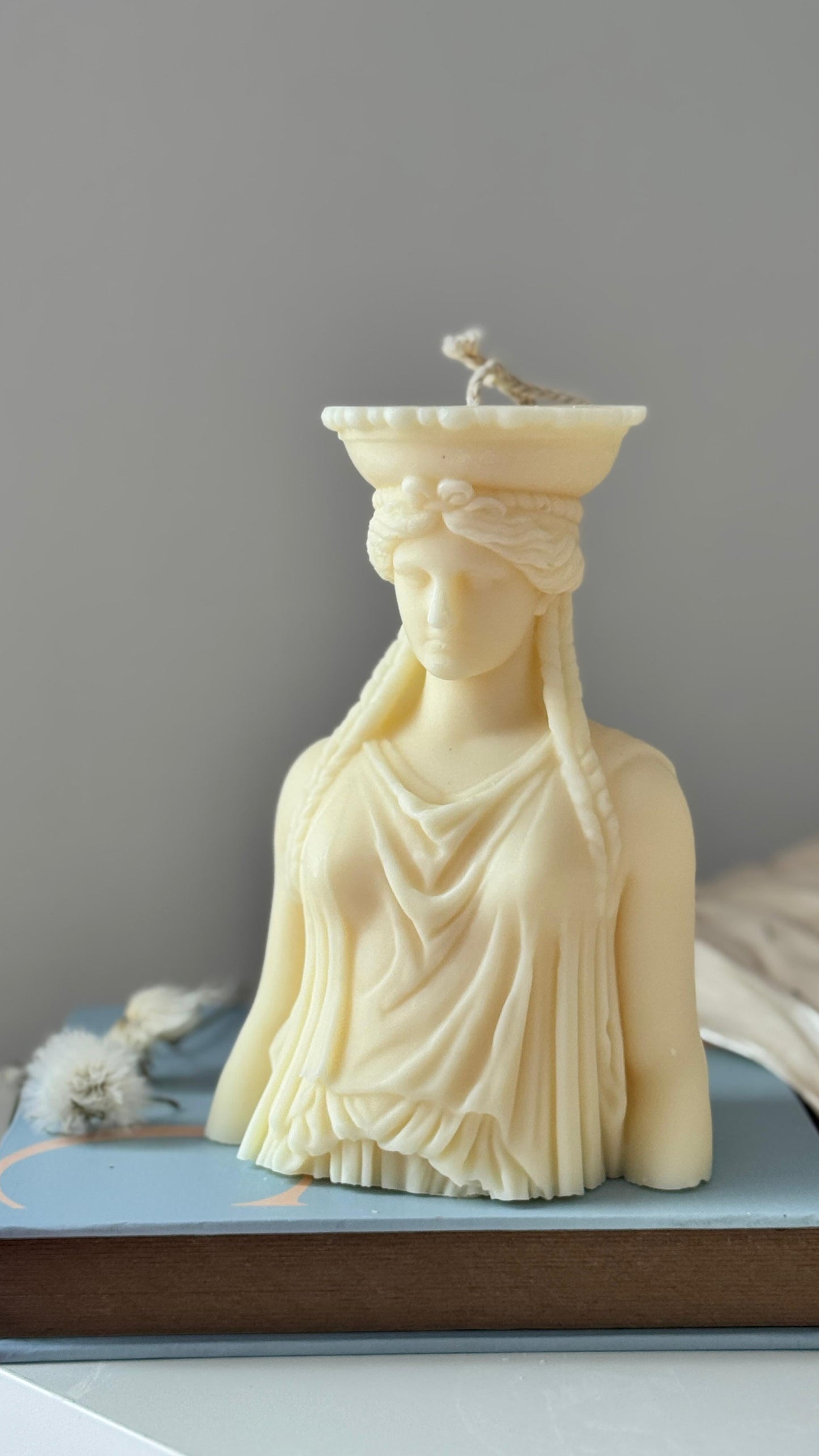 White marble bust on a gray surface with a neutral background
